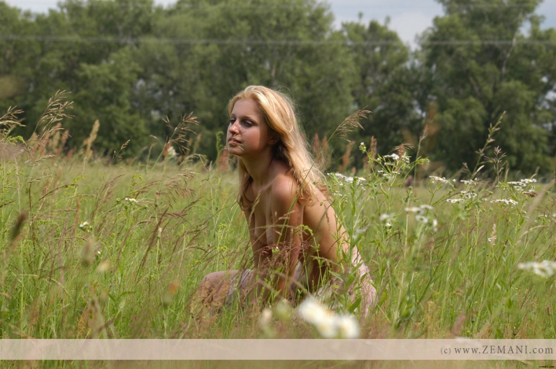 Натуральная красота привлекательной блондинки голышом на природе в высокой зеленой траве